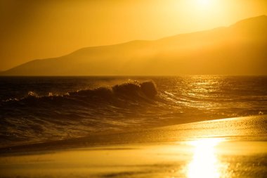 Okyanus ya da deniz dalgaları. Sahilde gün doğumu, günbatımı manzarası.