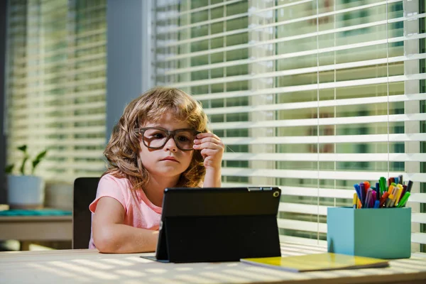 Kid estudante em óculos, aluno inteligente usando tablet em casa, aprendizagem on-line remotamente, Homeschooling, distanciamento social usando zoom facetime, Google meet, aplicativo quarto facebook, novo conceito normal. — Fotografia de Stock