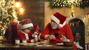 Şık sakallı Noel Baba Noel için zencefilli kurabiye pişirir. Noel Baba çocuk yardımcısı Xmas 'ı ya da yeni yılı hazırla.