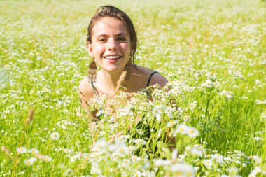 Bahar Kızı. Güzel Bahar Genç Kadını Doğanın tadını çıkarıyor. Yeşil Çimenli Gülümseyen Genç Kadın. Spring Meadow 'da. Sahadaki Güzel Bayan.
