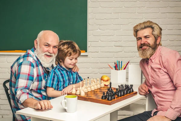 Otec učí syna hrát šachy. Dědeček vzdělával vnuka. Koncept dědečka a vnuka. — Stock fotografie