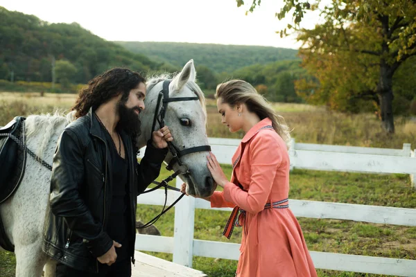 Happy couple and beautiful white horse. Loving couple with horse on ranch. — Stock Photo, Image