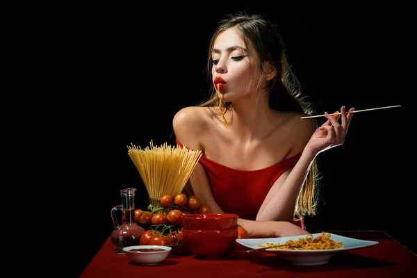 Una mujer sensual come espaguetis. Concepto de comida saludable. Hambre y apetito. Chica sorprendida con fideos de espagueti. Macarrones largos de pasta. — Foto de Stock