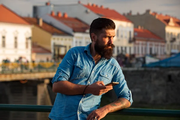 Jovem barbudo enviando mensagens no celular. — Fotografia de Stock