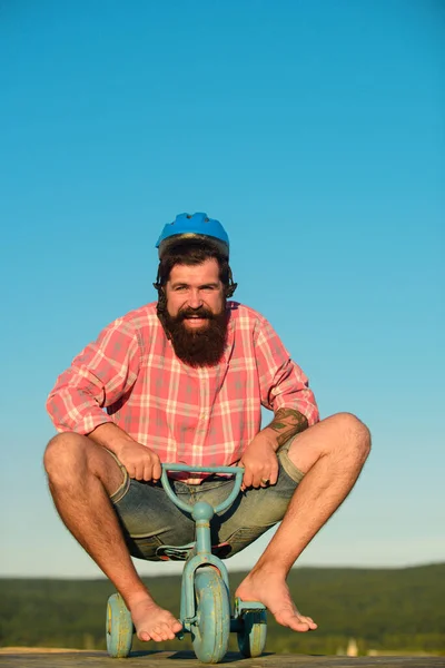 Rolig man på cykel. Känslomässig galen kille på barncykel. Nördig hipster kille rider en liten cykel. — Stockfoto