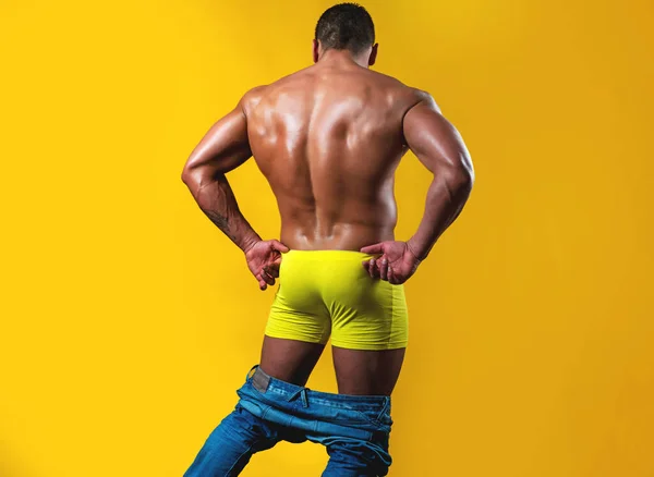 Gay panties down. Naked mens back and shoulders on isolated on yellow. Metrosexual concept. Shirtless undressed sexy man. Masculine buttocks. — Stock Photo, Image