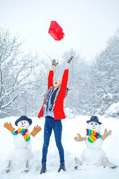 Smyslná zimní dívka pózuje a baví se. Šťastný dívčí portrét. Vánoční zimní pudl. Krása Zimní žena se sněhulákem v mrazivém zimním parku. — Stock fotografie