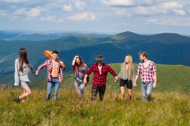 Dağda yürüyüş yapan arkadaşlar. Hafta sonu doğada. İnsanlar güneşli bir günde pikniğin tadını çıkarıyorlar. Yaz tatilleri.