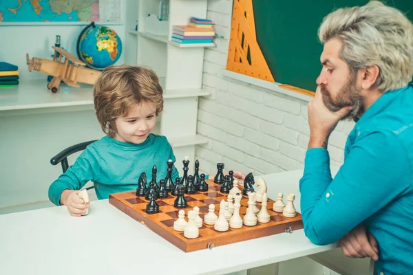 La fête des pères. Concentré garçon développant une stratégie d'échecs. Intelligent concentré et pensant enfant tout en jouant aux échecs. — Photo