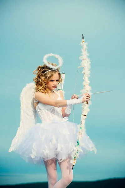 Cupidon fille visant quelqu'un avec une flèche d'amour. Flèche d'amour. Beauté bleu ses yeux charmante dame dans la lumière du soleil. Ange enfant fille aux ailes blanches. Joyeuse Saint Valentin — Photo