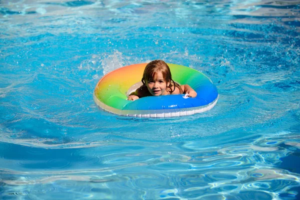 Niño en la piscina jugando en el agua. Vacaciones y viajes con niños. Los niños juegan al aire libre en verano. Niño con anillo flotante. Estilo de vida saludable. —  Fotos de Stock
