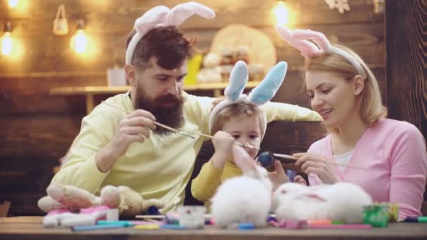 La famiglia pasquale dipinge uova. Genitorialità. Ragazzo con le orecchie da coniglio. — Video Stock
