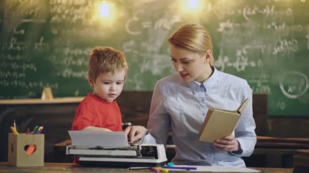 Criança pré-escolar. Mãe e filho a escrever na máquina de escrever. Estudante sentado na sala de aula. — Vídeo de Stock