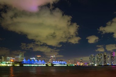 Miami, Florida, Biscayne Körfezi 'ndeki ABD silueti, şehir geceleri. Miami şehrinin gökdelenleri ve deniz üzerinde yansıması olan gökdelenleri..