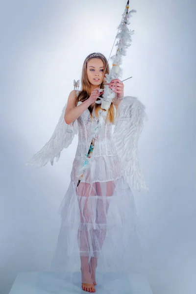 Cupido fêmea bonito dispara um arco. Rapariga inocente. Menina adolescente bonito. Cupido bonito menina com um arco. Dia dos namorados. — Fotografia de Stock