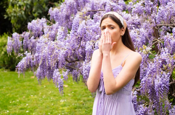 Alergia à primavera. Rapariga com espirros nasais. Conceito de sintoma alérgico. Mulher sendo alérgica à flor fora. — Fotografia de Stock