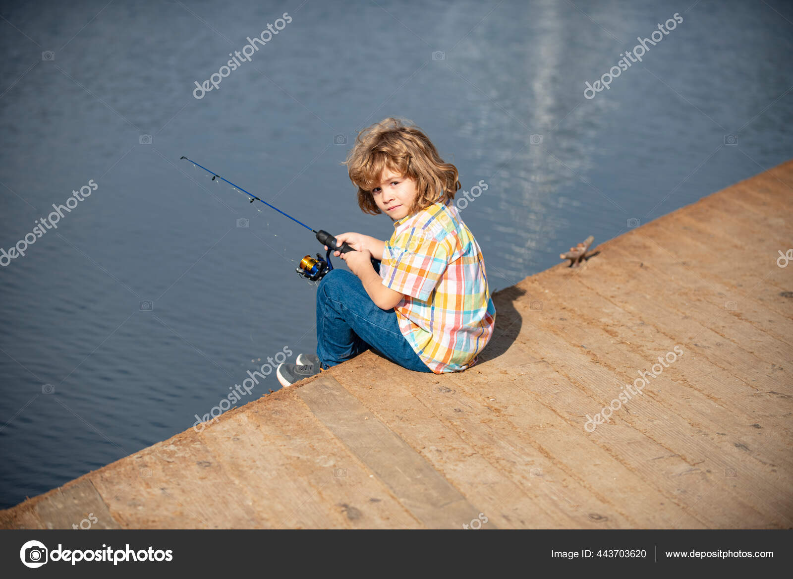 Young child fisher. Kid fishing at river bank, summer outdoor