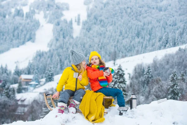 Χειμερινό πικνίκ κατασκήνωση για παιδιά. Αστείο μικρό αγόρι και κορίτσι με χειμωνιάτικα ρούχα περπατά κατά τη διάρκεια μιας χιονιού. Εξωτερικές χειμερινές δραστηριότητες για παιδιά. Χαριτωμένα παιδιά πίνουν ζεστό τσάι. — Φωτογραφία Αρχείου