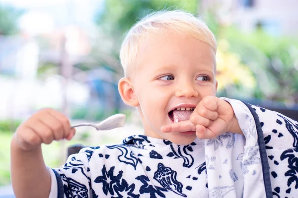 Baby eating with spoon. Kid food. Kids nutrition. Healthy food for children. — Stock Photo, Image