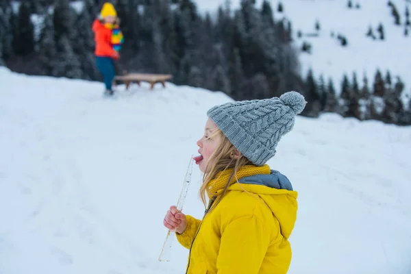 Fille enfant lécher la glace et manger de la neige en hiver. Enfants d'hiver amusant. — Photo