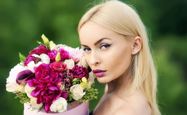 Frau mit Blumenstrauß, weibliches Make-up Mädchen Geschenk. Ideale blonde Haare, perfekte Haut. — Stockfoto