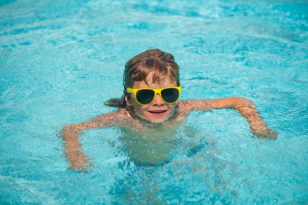 Ragazzo che gioca e si diverte sulla spiaggia in mare in estate. Oceano blu con wawes. Bambino ragazzo nuotare in mare. — Foto Stock