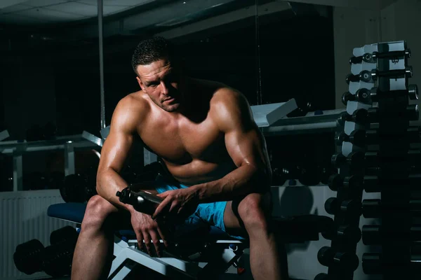 Sportivo o sportivo nel concetto di palestra. Maschio sportivo con busto nudo. Un ragazzo dell'allenamento. Esercizi con manubri. Sportivo con corpo atletico potente. — Foto Stock