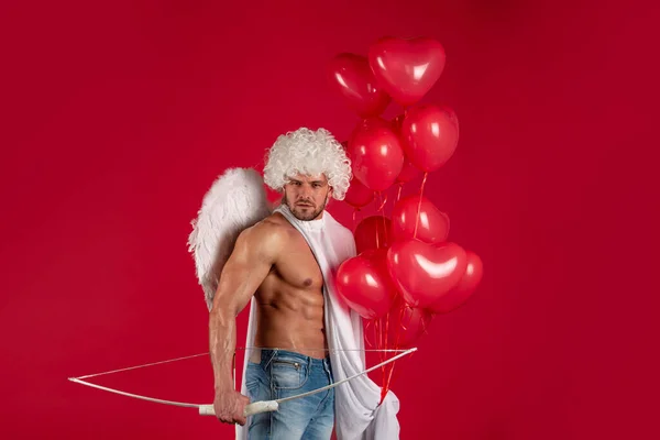 Um anjo bonito. Conceito do Dia dos Namorados. Um atleta sexy com asas de anjo. Cupido. Amour. 14 de Fevereiro. Flecha do amor. Isolado em vermelho. — Fotografia de Stock