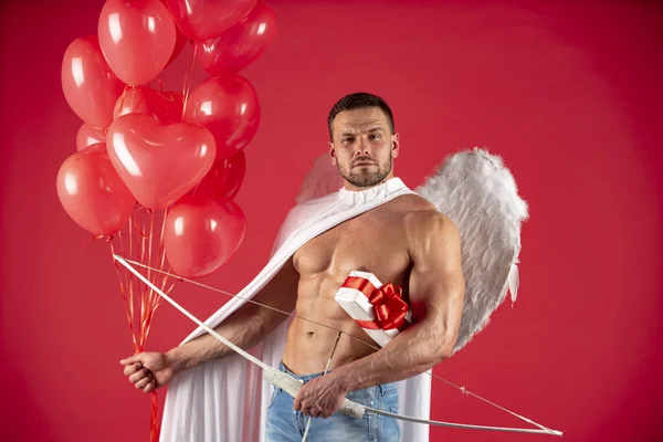 バレンタインデーの男性。天使の翼を持つセクシーな天使の男。愛の矢、キューピッド、アムール。2月14日。赤に隔離された. — ストック写真