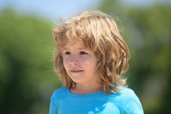 Primo piano volto bambini attraenti. Concetto di emozioni infantili. Ritratto di giovane bambino sorridente all'aperto. Sfocatura sfondo. — Foto Stock