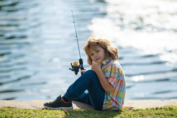 Kinderangeln im Fluss. Jungfischer. Freizeitaktivitäten im Sommer. Kleiner Junge angelt mit Rute am Flussufer. — Stockfoto