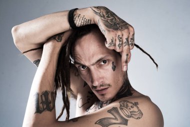 Orta parmak. Yakışıklı, dövmeli adam. Erkek dövmesi modası. Acımasız adam..