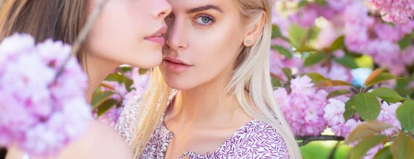 Ragazze primaverili. Outdoor close up ritratto di giovane bella ragazza alla moda posa vicino albero di sakura in fiore con fiori rosa. Baner, copiare spazio. — Foto Stock