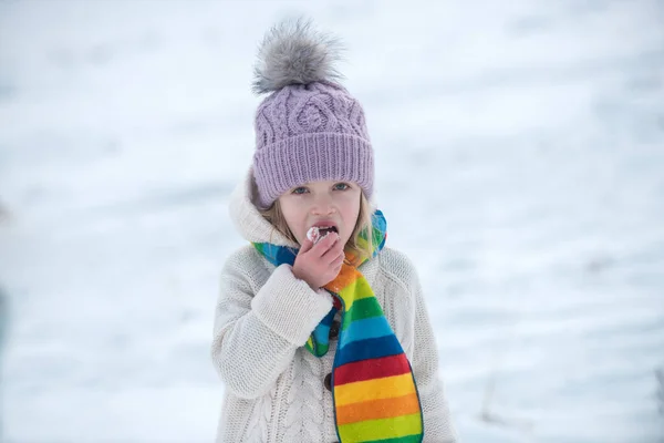 Child eat snowflakes. Kid girl lick and eating snow in winter. Winter fun. — Stock Photo, Image