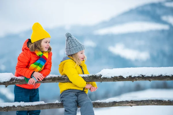 Glückliche Kinderfreunde im Schnee. Kleine Mädchen und Jungen haben Spaß am Wintertag. — Stockfoto