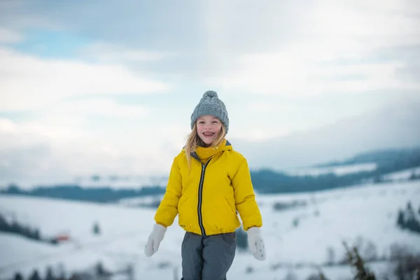 Vtipná zimní holka. Děti si hrají se sněhovými vločkami. — Stock fotografie