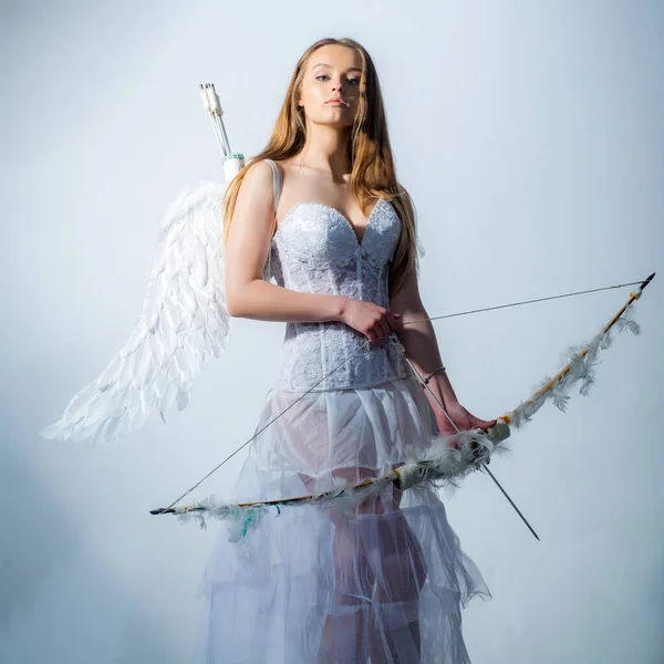 Bonita niña blanca como el Cupido con un arco y flecha felicitando el día de San Valentín. Tarjeta de regalo de San Valentín - Vacaciones adolescente Cupido con amor. — Foto de Stock