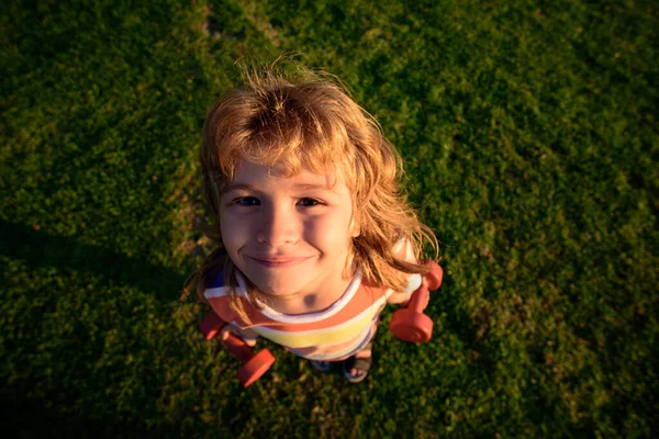 Funny child face. Kid with dumbbells. Wide angle. Sport workout and people health. — Stock Photo, Image