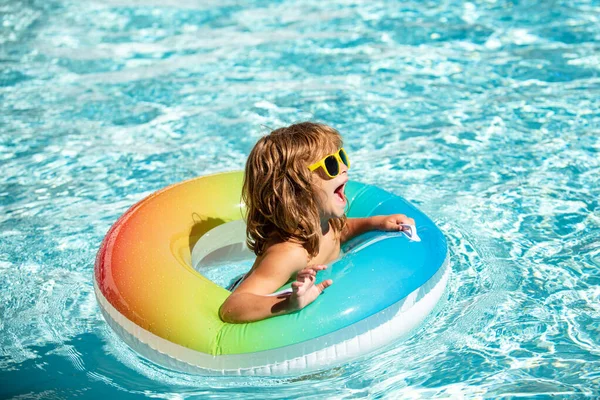 Crianças férias de verão. Criança nadando na piscina. Miúdo a divertir-se no Aquapark. Menino engraçado no círculo de borracha inflável. Hora de Verão. Conceito de atracções. — Fotografia de Stock