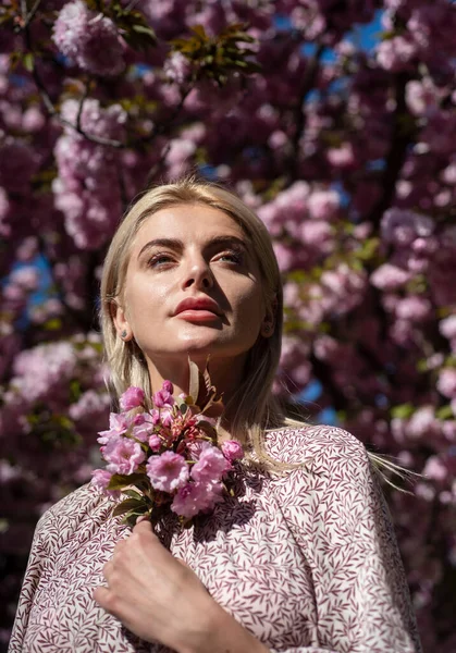 Girl in in blossoms cherry sakura. Outdoor portrait of beautiful sensual fashion girls posing near blooming tree with pink flowers. — Stock Photo, Image