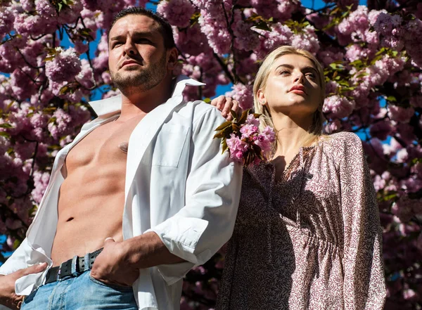 夏天的花园子里，性感的女人和男人在粉色的花朵里。男人和女人. — 图库照片