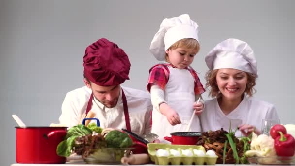 Dapur keluarga. Orang tua dengan anak memasak. Makanan rumah yang sehat. Orangtua dan anak-anak. — Stok Video