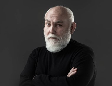 Yaşlı, yaşlı, olgun bir adam kıdemli adamın portresini yakından çekiyor. Siyah arka planda olgun bir adamın portresi.