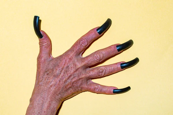 Manicure di Halloween da primo piano. Vecchie mani spaventose con lunghe unghie nere. Demone o diavolo in vacanza di Halloween. — Foto Stock