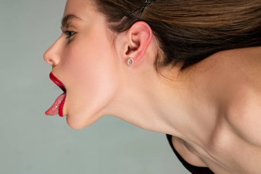 Uzun saçlı kadın. Saç bakımı. Seksi kız dil gösteriyor. Kadın kozmetik ürünleri. Cilt bakımı.