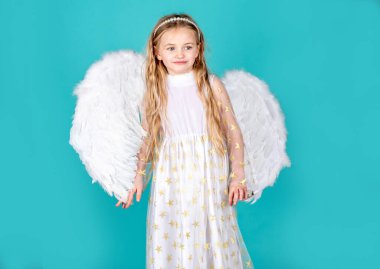 Bir meleğe benziyor. Renkli arka planda güzel bir melek kızın yüzü. Meleğim. Melek yüzlü çocuk. Noel Sevimli Küçük Melek.