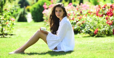 Kahve doğası. Gül tarlasında kahveli bahar kadını. Gül bahçesinde mutlu bir kız. Kadınlar açık havada eğlenmeyi sever. Doğal güzellik..