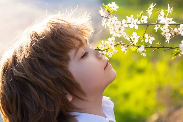 Feliz infância. Criança da primavera com árvore florescente. Criança bonito no jardim da flor. — Fotografia de Stock