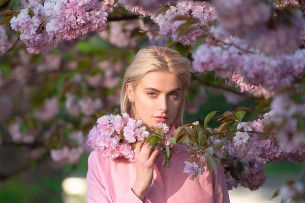 Κορίτσι με άνθη κερασιάς σακούρα. Εξωτερικό πορτρέτο των όμορφων αισθησιακών κοριτσιών μόδας που ποζάρουν κοντά σε ανθισμένο δέντρο με ροζ λουλούδια. — Φωτογραφία Αρχείου