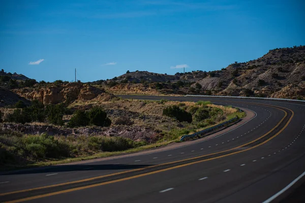 Paisagem americana natural com estrada de asfalto para o horizonte. Cenário estéril. — Fotografia de Stock